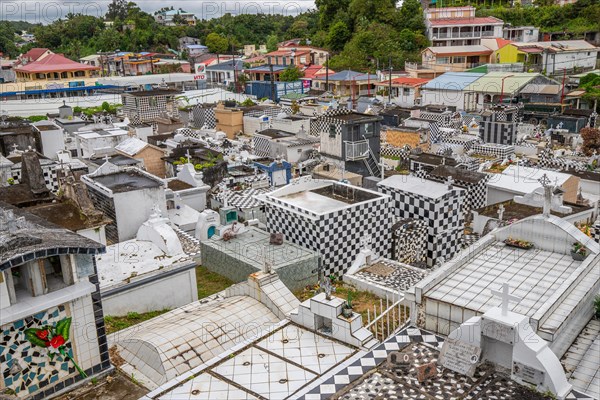 Famous cemetery, many mausoleums or large tombs decorated with tiles, often in black and white. Densely built buildings under a dramatic cloud cover Cimetiere de Morne-a-l'eau, Grand Terre, Guadeloupe, Caribbean, North America