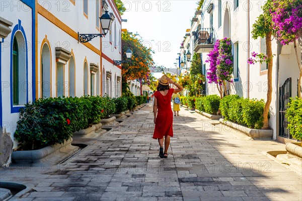 A woman walking in the port of the flower-filled coastal town Mogan in the south of Gran Canaria. Spain