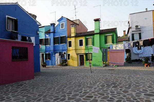 Colourful houses, Burano, Burano island, square in Burano with laundry hanging between colourful houses, Burano, Venice, Veneto, Italy, Europe
