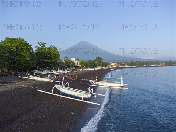 Fishermen unload their catch from their outrigger boat in the morning, in the background Gunung Agung, Amed, Karangasem, Bali, Indonesia, Asia