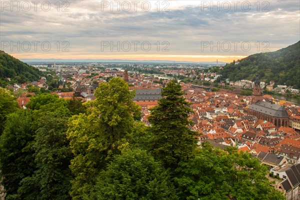View over an old town with churches in the evening at sunset. This town lies in a river valley of the Neckar, surrounded by hills. Heidelberg, Baden-Wuerttemberg, Germany, Europe