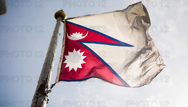 The flag of Nepal, fluttering in the wind, isolated against a blue sky