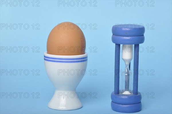 Boiled egg and hourglass on a blue background