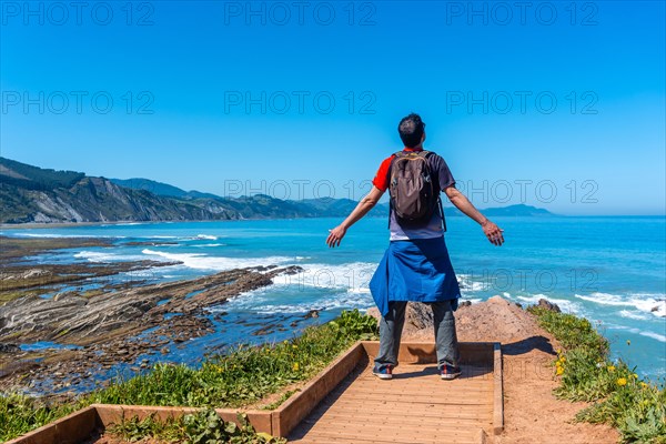 A tourist hiker visiting the Flysch Basque Coast geopark in Zumaia at the Algorri Viewpoint, Gipuzkoa