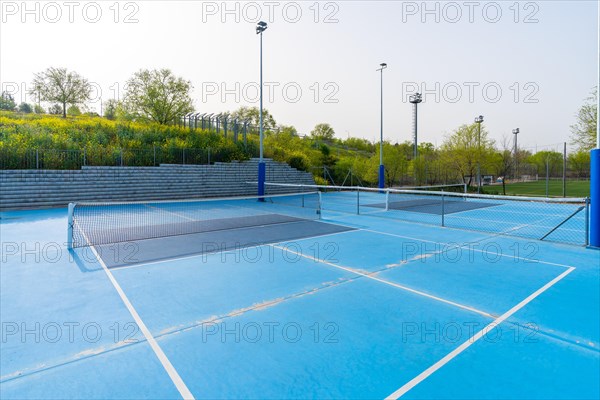 Empty new blue outdoors pickletball and tennis courts in a sunny day
