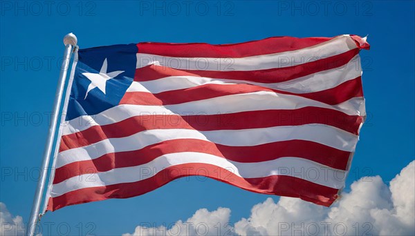 The flag of Liberia, fluttering in the wind, isolated, against the blue sky