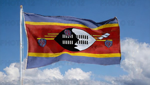 The flag of Swaziland, Kingdom of Eswatini, flutters in the wind, isolated, against the blue sky