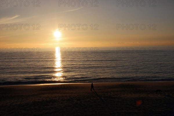 Beach 5 km south of Westerland, Sylt, North Frisian Island, Schleswig Holstein, Beach at sunset with the silhouette of a person and the sun reflected in the water, Sylt, North Frisian Island, Schleswig Holstein, Germany, Europe