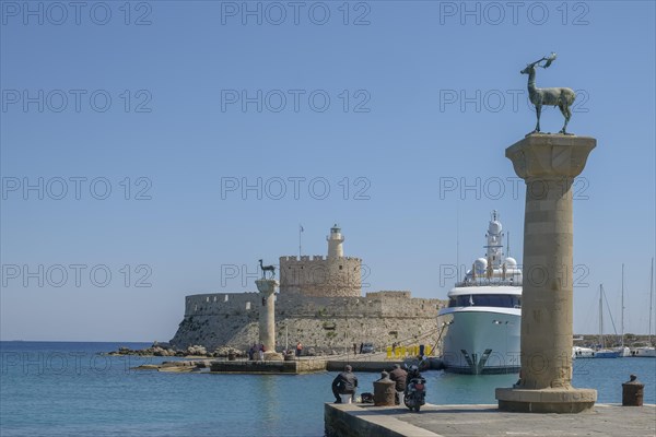 Elafos and Elafina, stag and hind, sculptures on columns, harbour entrance Mandraki harbour, fortress Agios Nikolaos with lighthouse, Rhodes, Dodecanese archipelago, Greek Islands, Greece, Europe