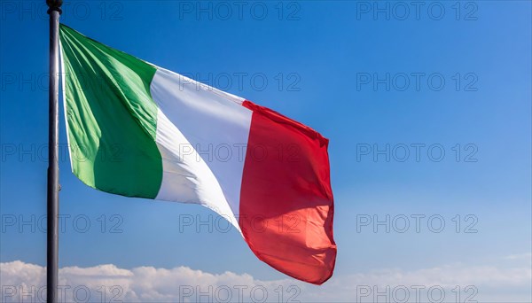 The flag of Italy flutters in the wind, isolated against a blue sky