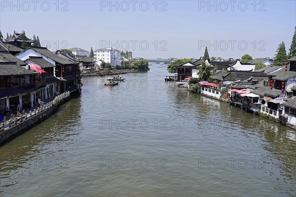 Excursion to Zhujiajiao water village, Shanghai, China, Asia, wooden boat on canal with view of historic architecture, view of a river with boats and traditional buildings on both banks, Asia