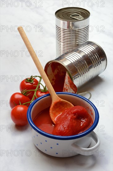 Tinned tomatoes in a bowl, tin can and tomatoes