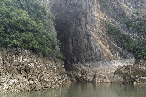 Cruise ship on the Yangtze River, Hubei Province, China, Asia, Breathtaking rock formation with cave next to a quiet river, Yichang, Asia
