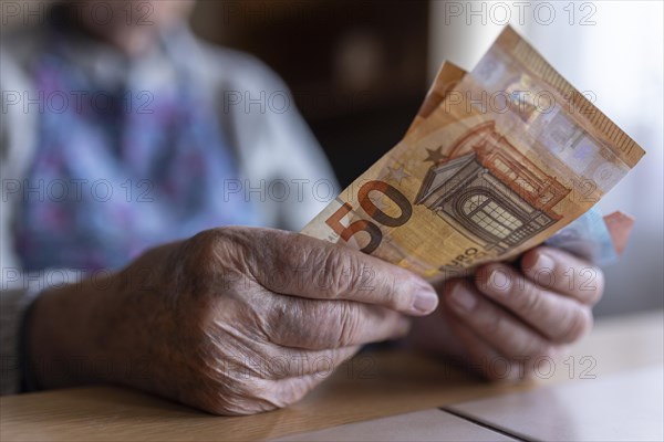 Wrinkled hands of a senior citizen with banknotes at home in her living room, close-up, Cologne, North Rhine-Westphalia, Germany, Europe