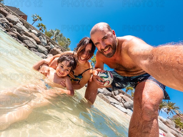 Selfie of a family on vacation on a beach in the Canary Islands. Concept of happy family outdoors. Family vacation on the sea coast