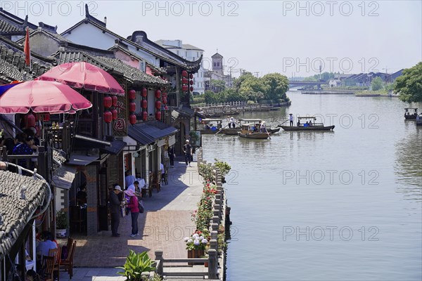 Excursion to Zhujiajiao water village, Shanghai, China, Asia, wooden boat on canal with view of historical architecture, people walking along a promenade with traditional Chinese architecture, Asia