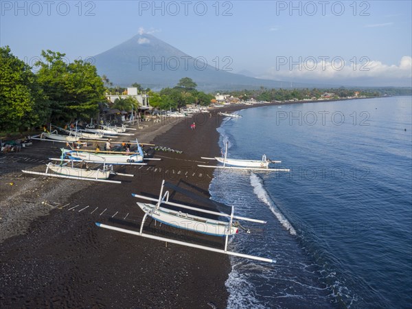 Fishermen loading fish from their outrigger boats in the morning on the black beach of Amed, Amed, Karangasem, Bali, Indonesia, Asia
