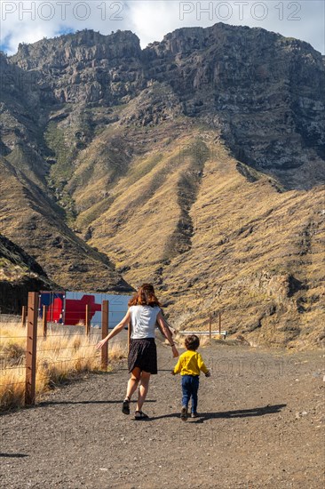 A mother and her son walking and having fun in the mountains of the Agaete coast, Roque Guayedra, Gran Canaria