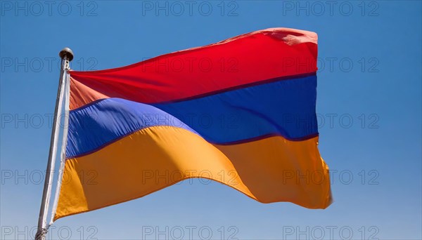 The flag of Armenia flutters in the wind, isolated against a blue sky