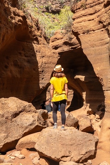 A woman with a hat in the limestone canyon Barranco de las Vacas on Gran Canaria, Canary Islands