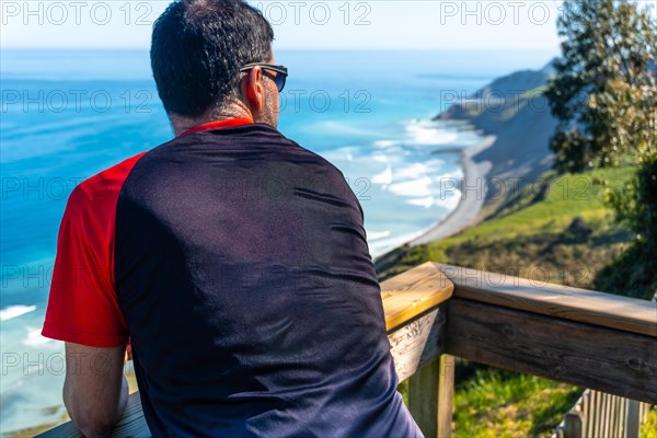 A man looking at the beautiful coastal landscape in the flysch of Zumaia, Gipuzkoa. Basque Country