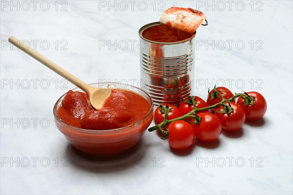 Tinned tomatoes in a bowl, tin can and tomatoes