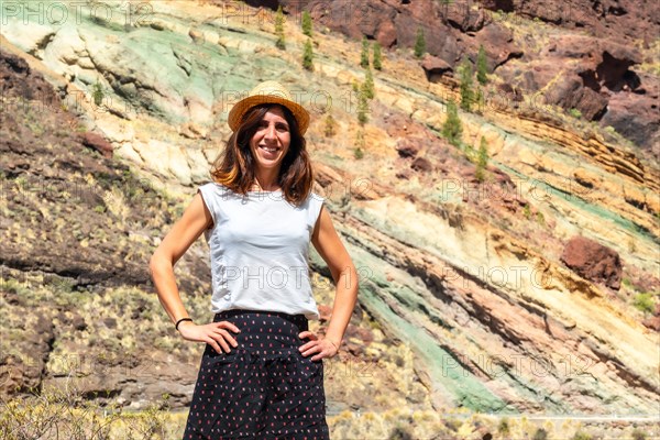 A hiker at the Azulejos de Veneguera or Rainbow Rocks Natural monument in Mogan, Gran Canaria