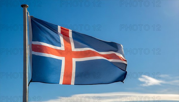 The flag of Iceland flutters in the wind, isolated against a blue sky