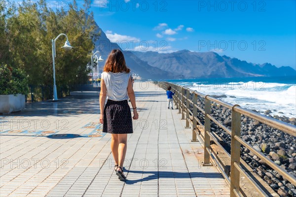 A woman strolling along the promenade in Agaete in Puerto de Las Nieves in Gran Canaria, Spain, Europe