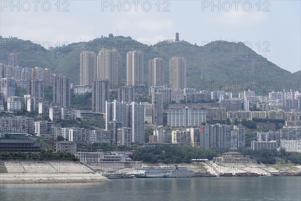 Chongqing, Chongqing Province, The view of an urban riverside landscape with dense development and mountain in the background, Chongqing, Chongqing Province, China, Asia
