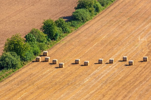 Aerial view at some straw bales on a stubble field after harvest