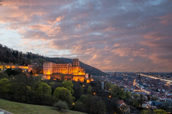 View over an old town with castle or palace rune in the evening at sunset. This town lies in a river valley of the Neckar, surrounded by hills. Heidelberg, Baden-Wuerttemberg, Germany, Europe