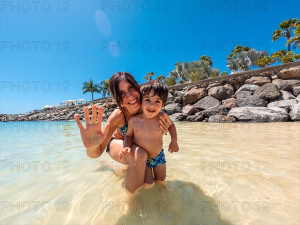 Mother and son on vacation on a beach in the Canary Islands. Concept of happy family outdoors. Family vacation on the sea coast