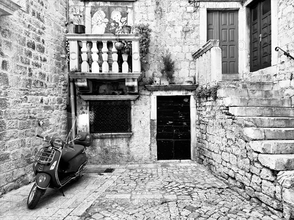 Black and white picture of a Vespa in an old-fashioned alley, Trogir, Dalmatia, Croatia, Europe
