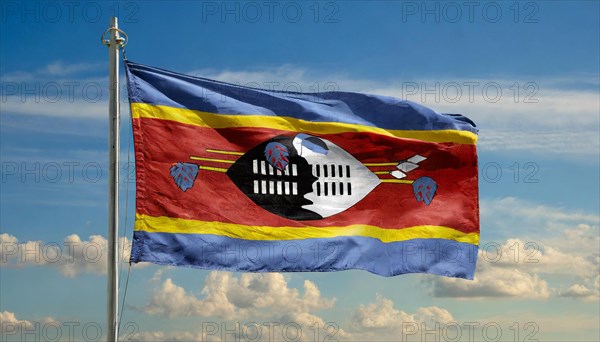 The flag of Swaziland, Kingdom of Eswatini, flutters in the wind, isolated, against the blue sky