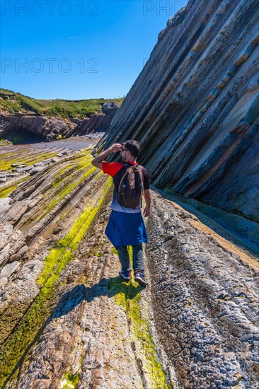 A male hiker visiting the Flysch Basque Coast geopark in Zumaia, Gipuzkoa