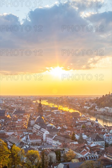 View over an old town with churches in the evening at sunset. This town lies in a river valley of the Neckar, surrounded by hills. Heidelberg, Baden-Wuerttemberg, Germany, Europe