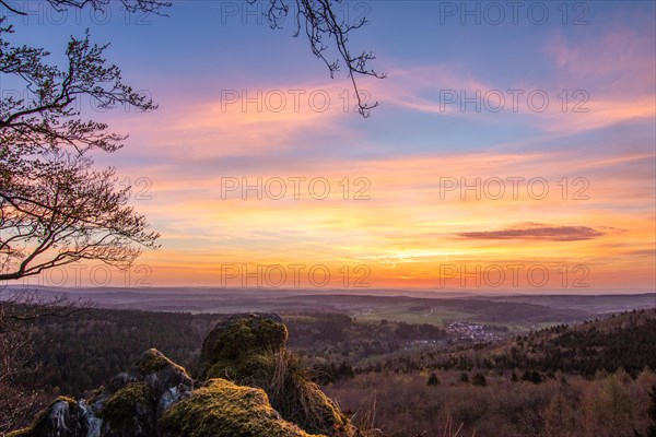 Panorama of a romantic landscape at sunset in the evening light. beautiful spring landscape in the mountains. Lawn and rolling hills. View from a cliff to the horizon. The Great Peak, Hesse, Germany, Europe