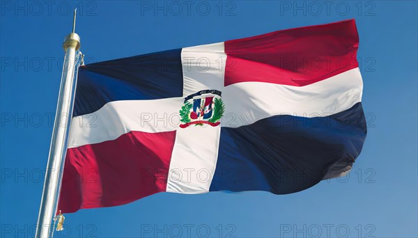 The flag of the Dominican Republic flutters in the wind, isolated against a blue sky