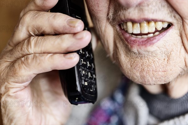 Mouth, hands and telephone receiver of a senior citizen making a phone call, close-up, Cologne, North Rhine-Westphalia, Germany, Europe