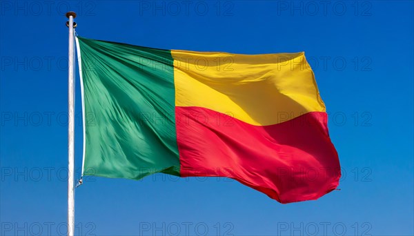 The flag of Benin flutters in the wind, isolated against the blue sky