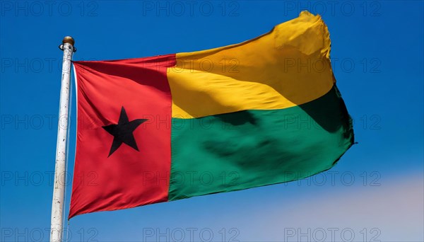 The flag of Guinea-Bissau, fluttering in the wind, isolated, against the blue sky