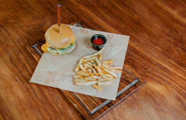 Top view of cheeseburger with french fries served on wooden table. Delicious hamburger with french fries on a wooden table