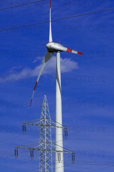 Electricity pylon with high-voltage lines and wind turbine at the Avacon substation Helmstedt, Helmstedt, Lower Saxony, Germany, Europe