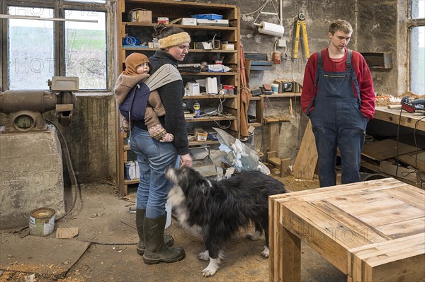 Family inspecting the table built by their son in the workshop, Mecklenburg-Vorpommern, Germany, Europe