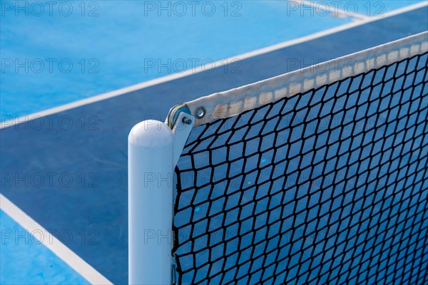 Close-up photo of the detail of a new tennis net on a pickleball court