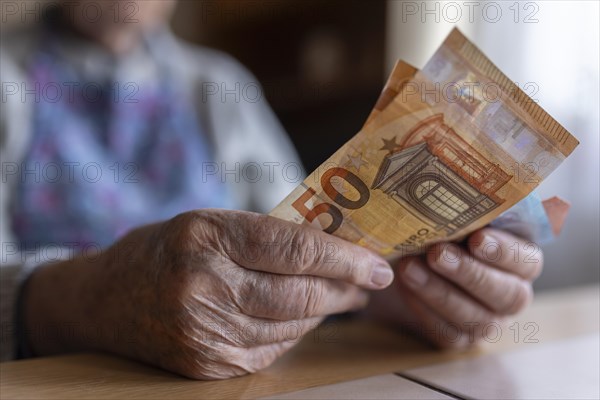 Wrinkled hands of a senior citizen with banknotes at home in her living room, close-up, Cologne, North Rhine-Westphalia, Germany, Europe