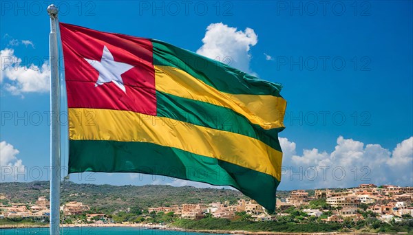 The flag of Togo flutters in the wind, isolated against a blue sky