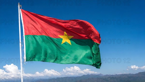 The flag of Burkina Faso flutters in the wind, isolated against the blue sky