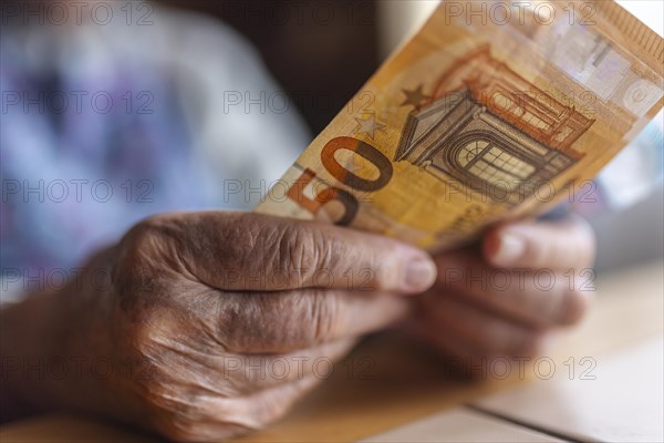 Wrinkled hands of a senior citizen with banknotes at home in her living room, close-up, Cologne, North Rhine-Westphalia, Germany, Europe